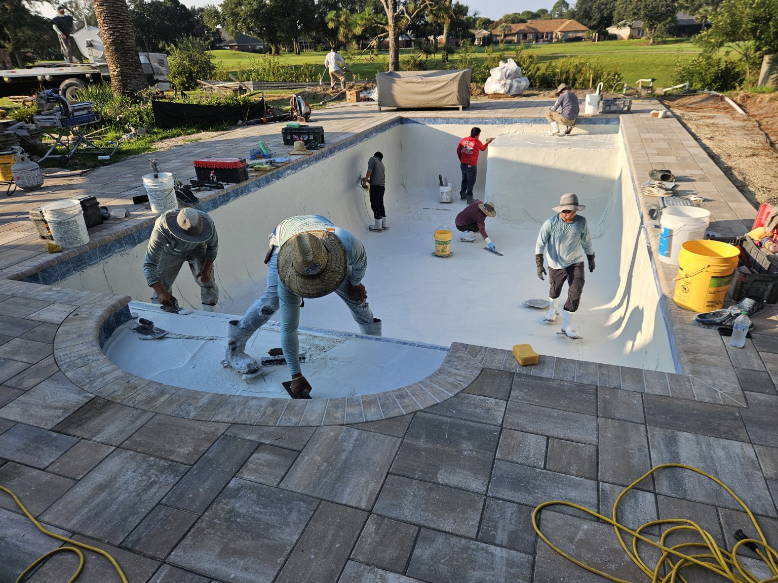 Craftsmen applying interior pool finish by hand