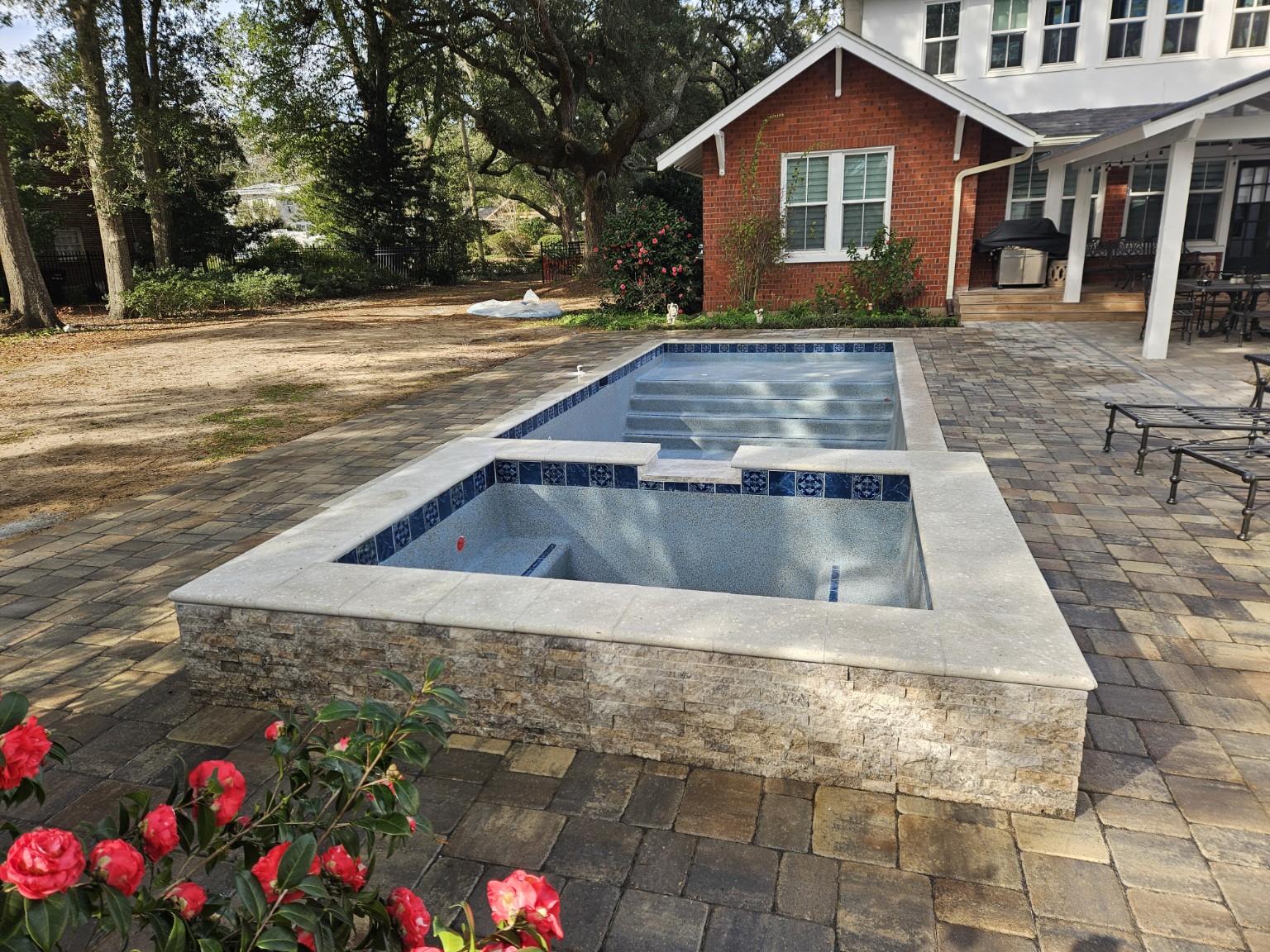 Raised spa with stone veneer and coping detail